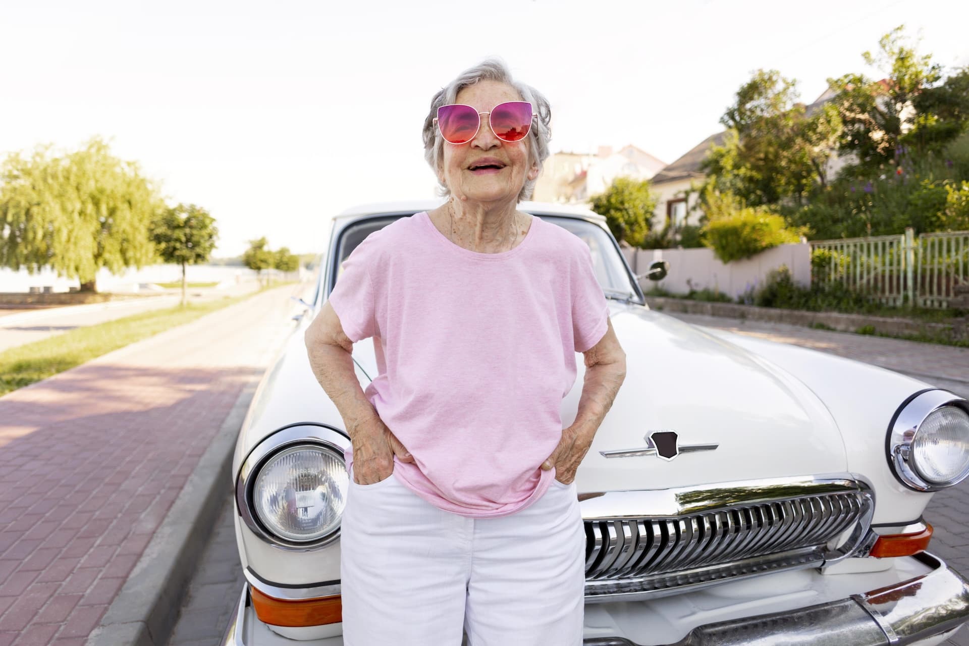 Happy senior woman standing by her car