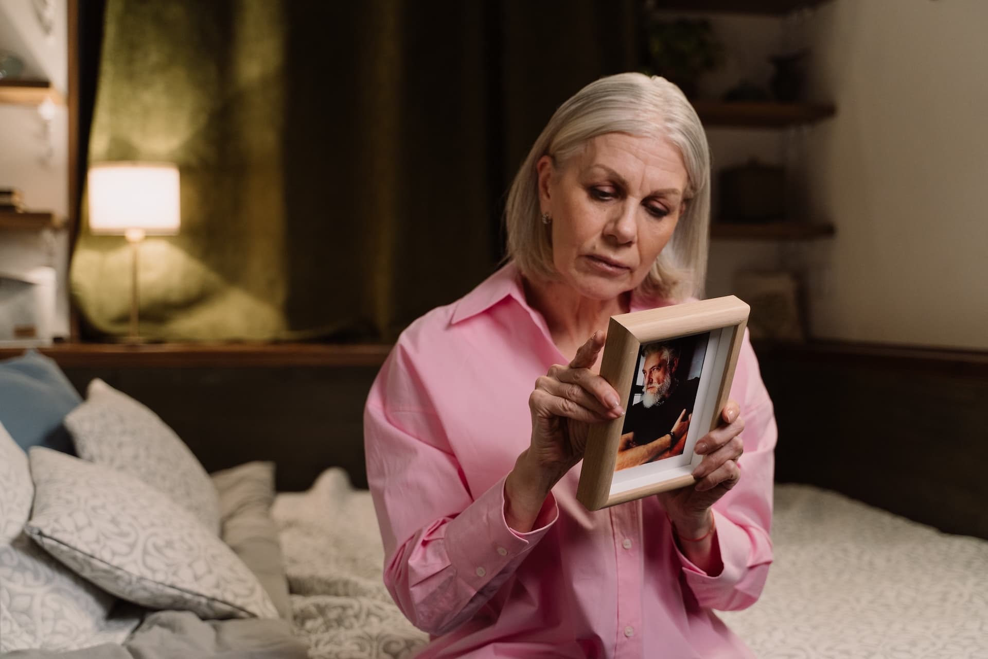 Woman nostalgic with picture of her husband