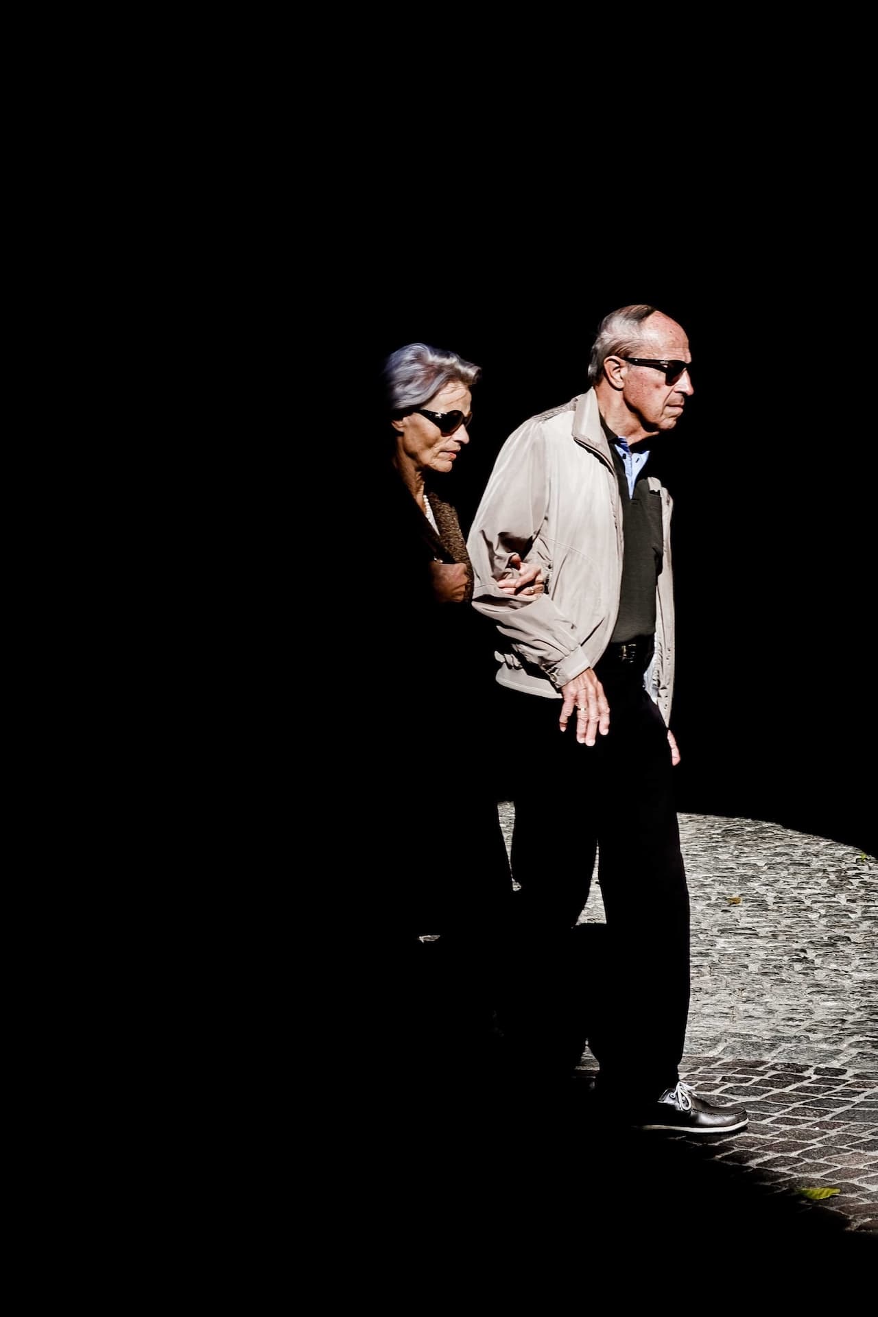Older couple walking out of shadow
